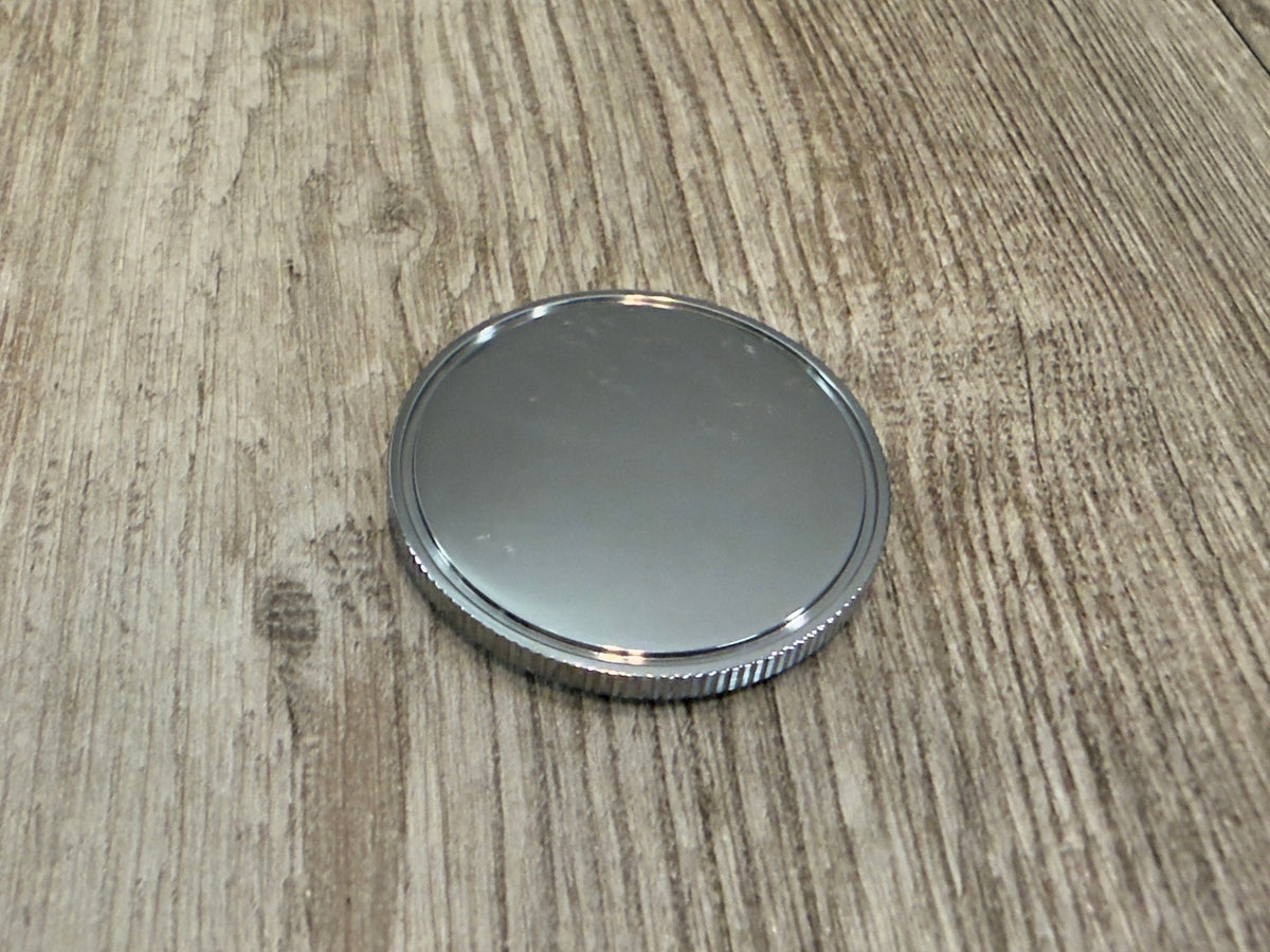Blank side of 40 mm Grade 5 titanium challenge coin showing machined groove and knurled side wall